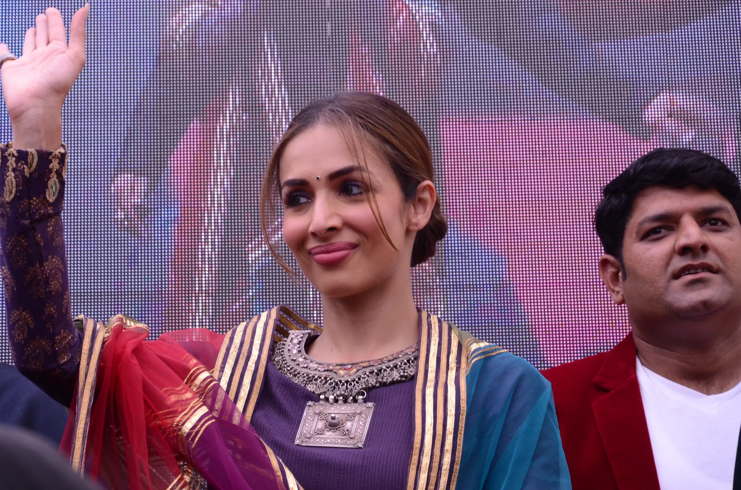 Balloon arch in orange, black, and white colors framing an ITT logo board lit with warm lights
